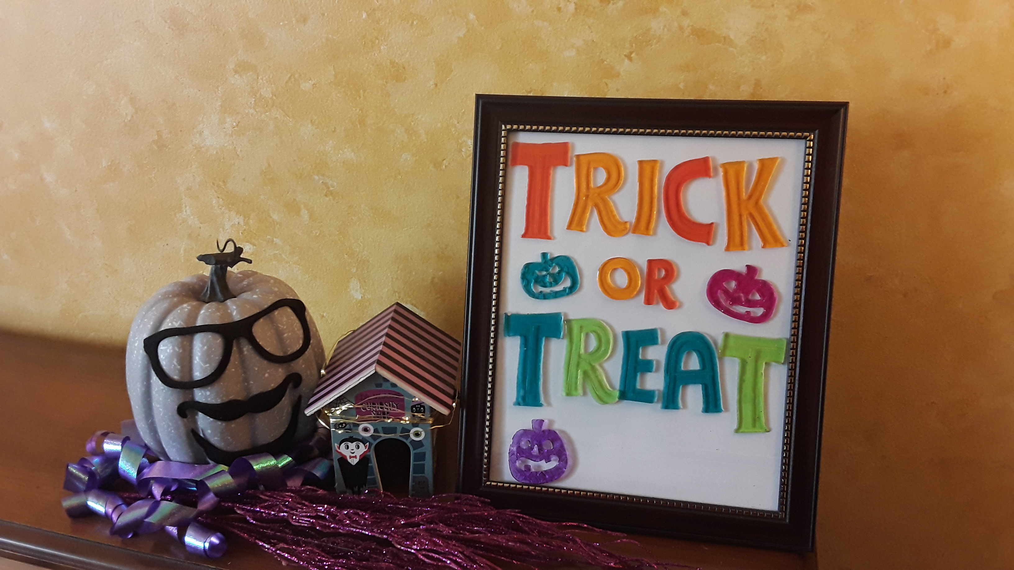 A decorated pumpkin and picture that says trick or treat