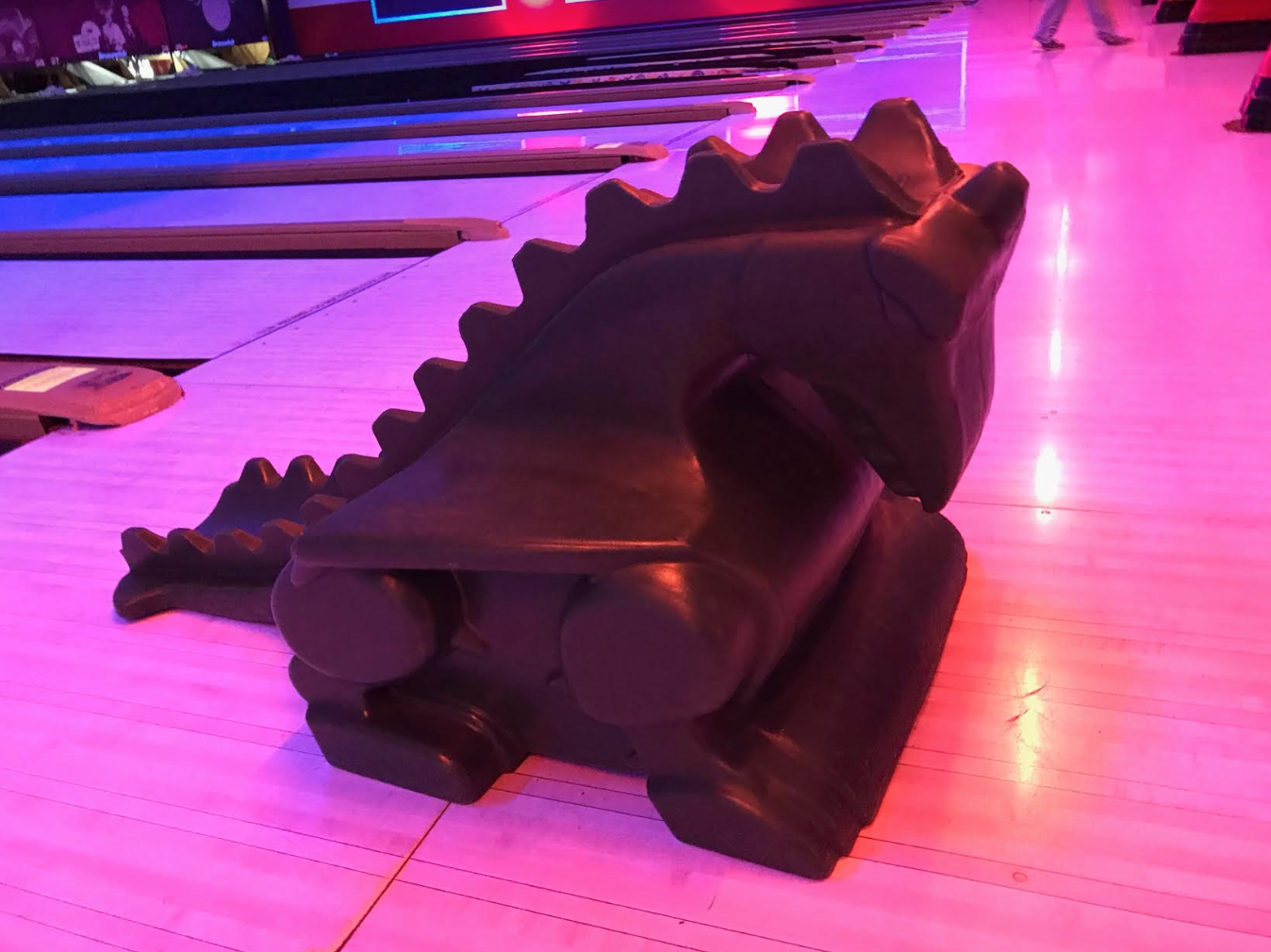 A lego dinosaur in a bowling alley