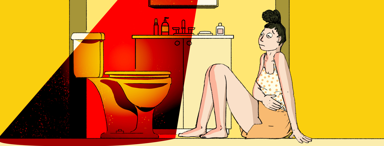 A woman sits uncomfortably on the bathroom floor with her hand over her stomach and staring warily at the toilet in front of her which is illuminated by an evil red light.